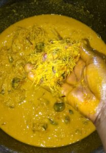 process-of-removing-palm-fruit-chaff-and-nut-from-the-pounded-palm-fruit-in-the-mortar